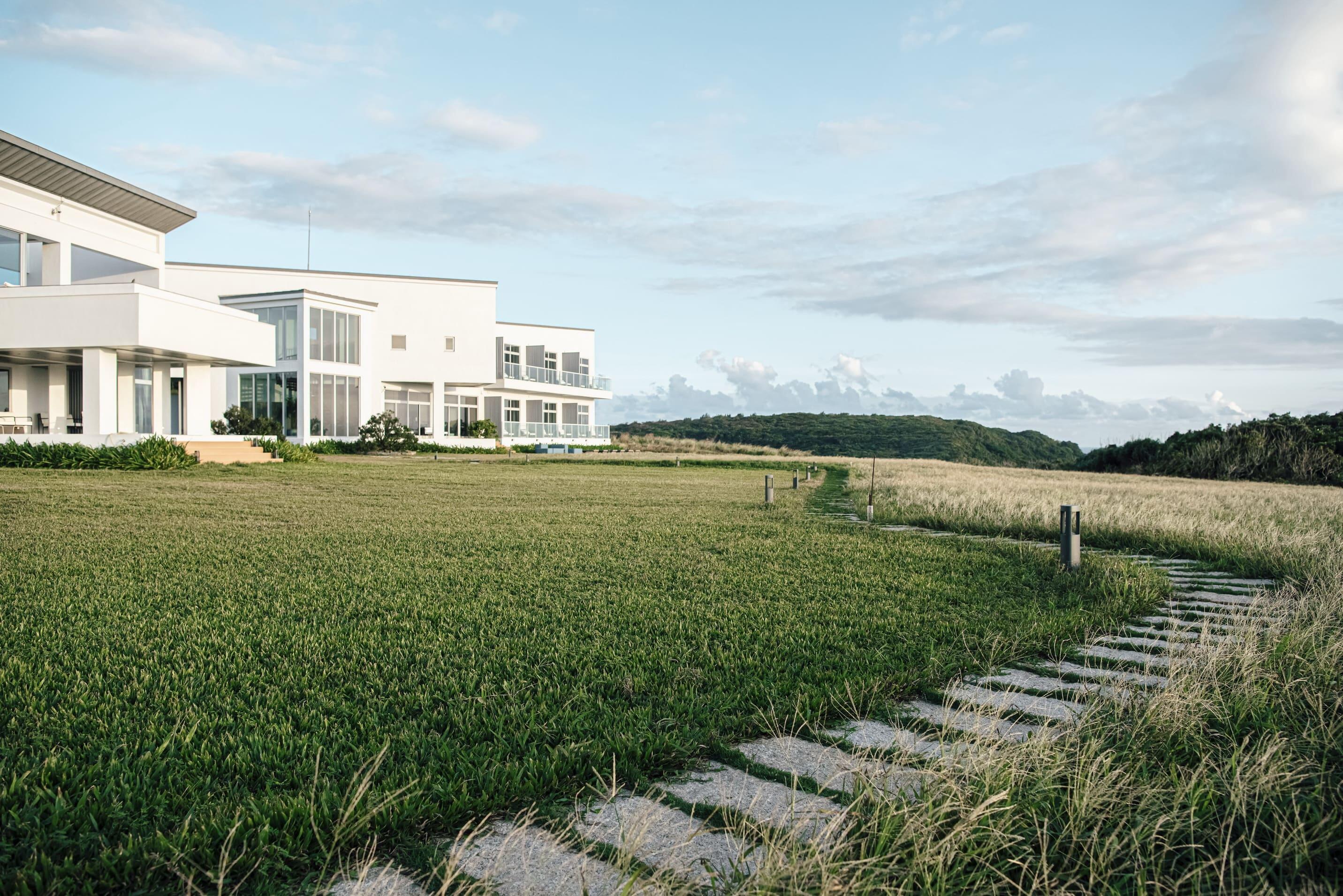 日光嶼南民宿位於墾丁，外型純白的建築與海天草原無縫相連。運用室內外交融的泳池與休憩空間，這是一間融合了現代美學與自然景觀的民宿設計案例。