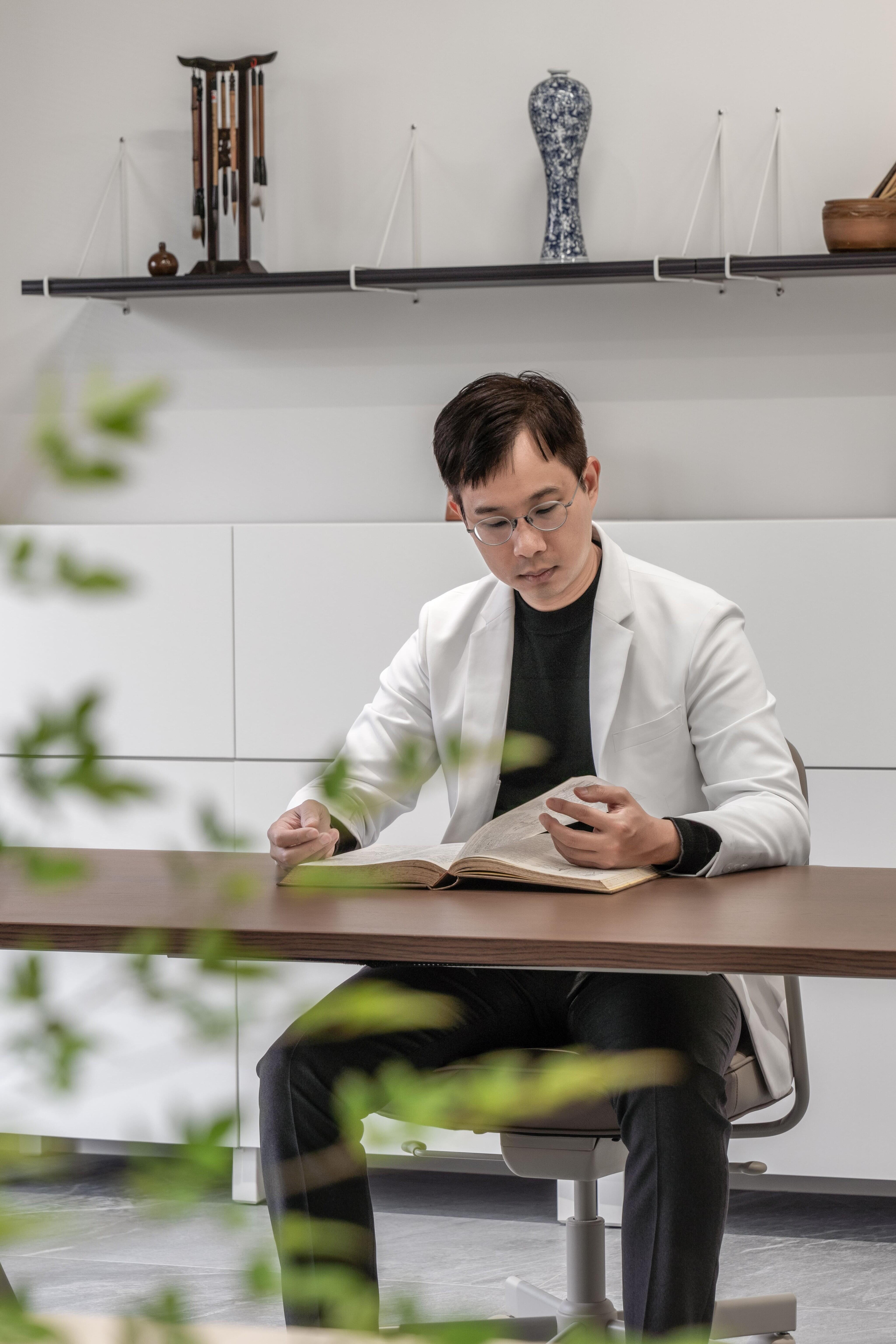 走進至和中醫辦公室，陽光灑落、綠意盎然。苔癬綠天花與漂浮文字牆延續自然氣息，開放書櫃劃分會議與辦公區，是值得參考的辦公室設計案例。